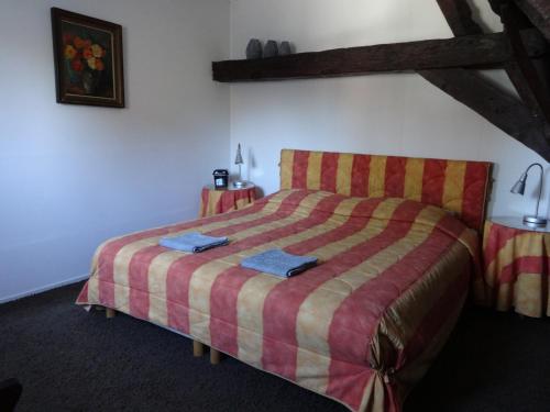 a bedroom with a large bed with a striped bedspread at Bed and Breakfast Corvel in Tilburg