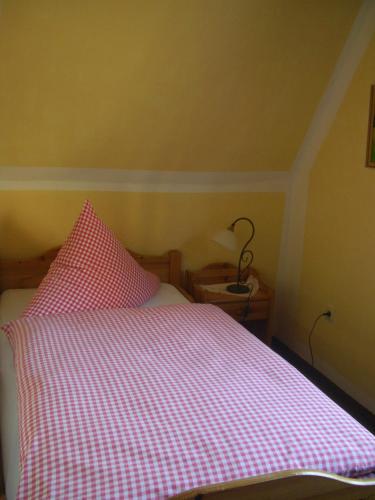 a bed with a red and white checkered blanket at Hotel-Restaurant Burg-Ramstein in Kordel