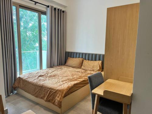 a bedroom with a bed and a window and a table at Axis Residences By The Team in Phnom Penh