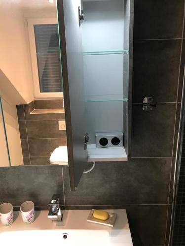 a bathroom with a sink and a mirror at New appartment Design Montreux in Montreux