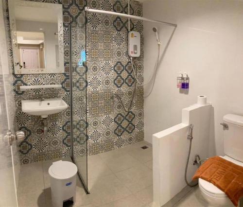 a bathroom with a shower and a toilet and a sink at Thong Prachok Hotel in Sakon Nakhon