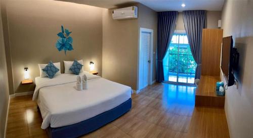 a bedroom with a large bed and a window at Thong Prachok Hotel in Sakon Nakhon
