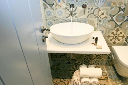 a bathroom with a bowl sink on a counter at Astropalia Luxury Studios in Astypalaia Town
