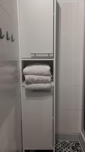 a white cabinet with towels in a bathroom at Self check-in Apartament Poznań Marcelin Lotnisko Ławica Szpitale Uczelnie in Poznań