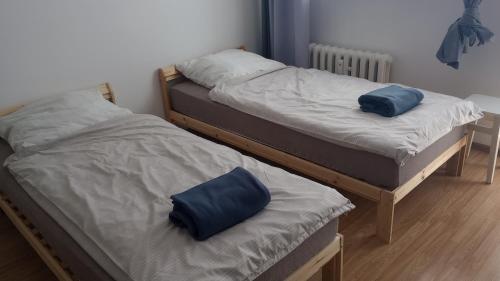 two beds with blue pillows on them in a room at Self check-in Apartament Poznań Marcelin Lotnisko Ławica Szpitale Uczelnie in Poznań