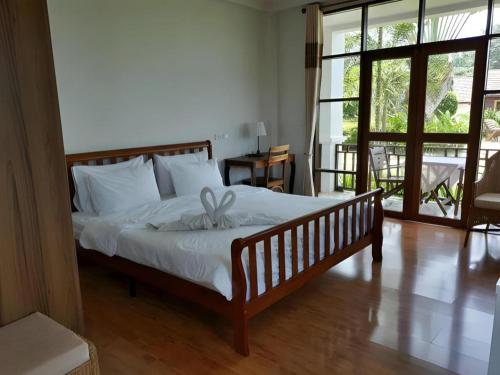 a bedroom with a bed with a bow on it at Gin's Greenery Resort in Ban Hua Wiang