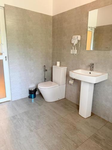 a bathroom with a toilet and a sink at vainika wild sigiriya in Sigiriya