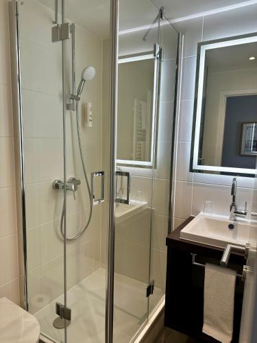 a bathroom with a shower and a sink at Hotel Friedrichstraße in Lampertheim