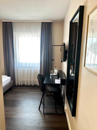 a hotel room with a desk and a window at Hotel Friedrichstraße in Lampertheim