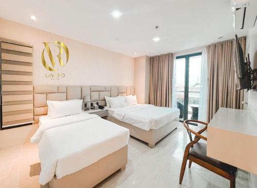 a hotel room with two beds and a television at LAVERO SUITES in Kalibo