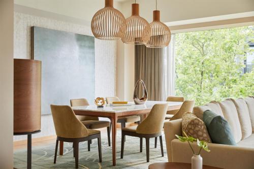 a dining room with a table and chairs and a couch at Park Hyatt Zurich – City Center Luxury in Zurich