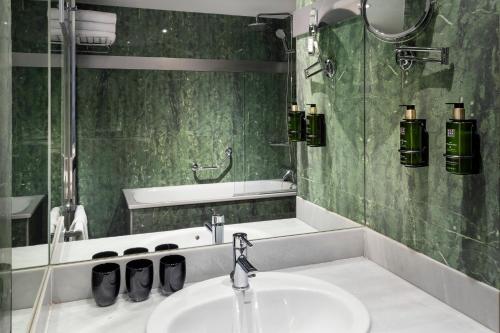 a bathroom with a sink and a bath tub at Meliá Lebreros in Seville