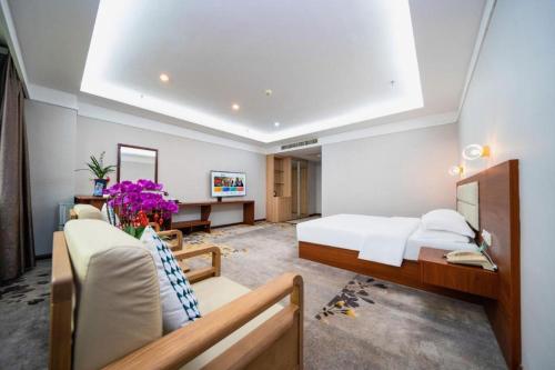 a hotel room with a bed and a desk at Bashan Hotel in Xiamen