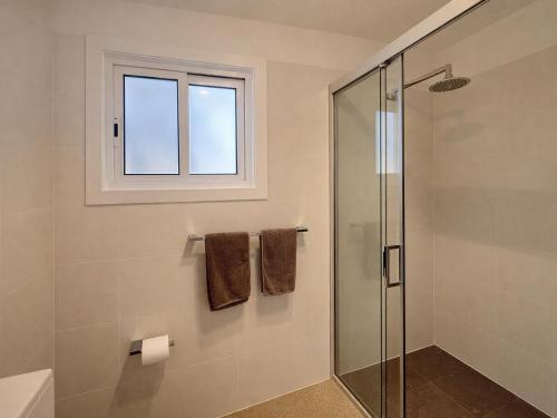 a bathroom with a shower and a window at Lakeside Forster Holiday Park in Forster