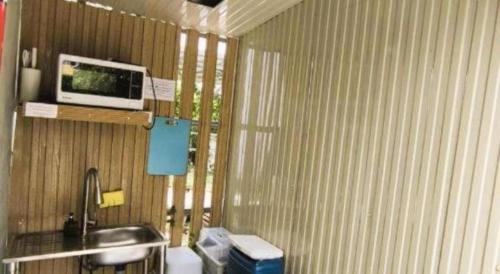 a bathroom with a sink and a computer on a shelf at 7 Class Pool Villa in Chachoengsao