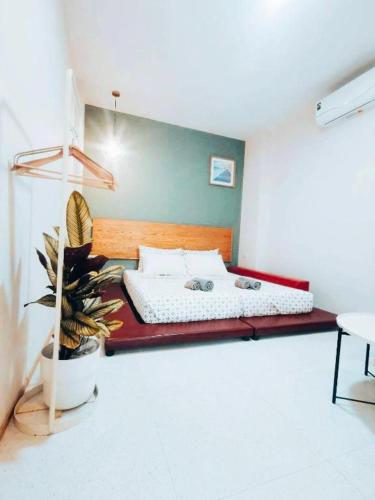 a bedroom with a bed in a room with a plant at 7 Class Pool Villa in Chachoengsao