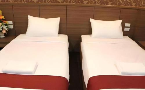 two beds sitting next to each other in a room at The Grace Residence in Surin