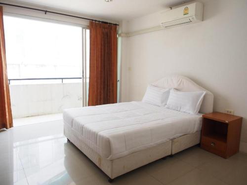 a white bed in a room with a window at Phetsuwan Hotel in Phetchabun