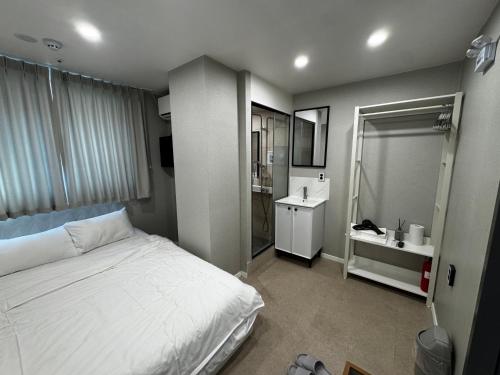a bedroom with a white bed and a sink at Mega Stay Dongdaemun in Seoul