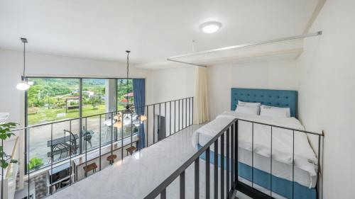 a bedroom with a bed and a balcony at Gapyeong Nomadrium poolvilla Pension in Gapyeong