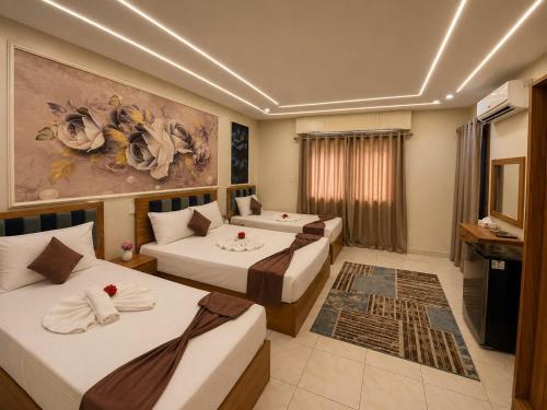 a hotel room with two beds and a television at Grand City Hotel River View in Cairo