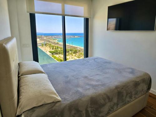 a bedroom with a large bed and a large window at Beachfront with pool and great views in Mataró