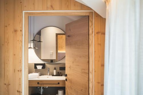 a bathroom with a sink and a mirror at Arthotel Gratschwirt in Dobbiaco
