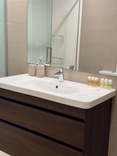 a bathroom with a white sink and a mirror at Beachfront with pool and great views in Mataró