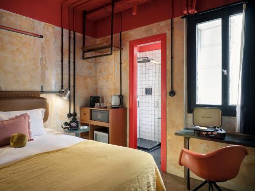 a bedroom with a bed and a chair and a window at Max Brown Hotel Downtown Part of Sircle Collection Formally known as Dave Red in Athens