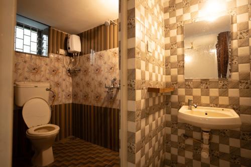 a bathroom with a toilet and a sink at Seraya Stays in Mandrem