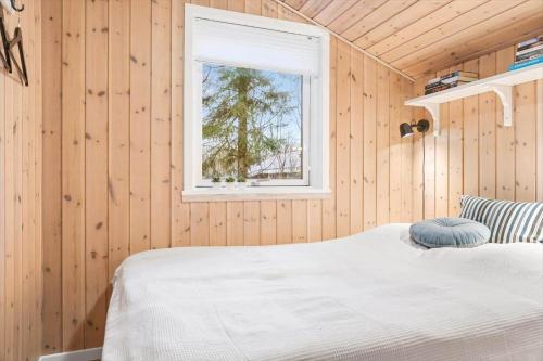 a bedroom with wooden walls and a bed with a window at 0664-Toftlund-Sydmarken-83 in Toftlund
