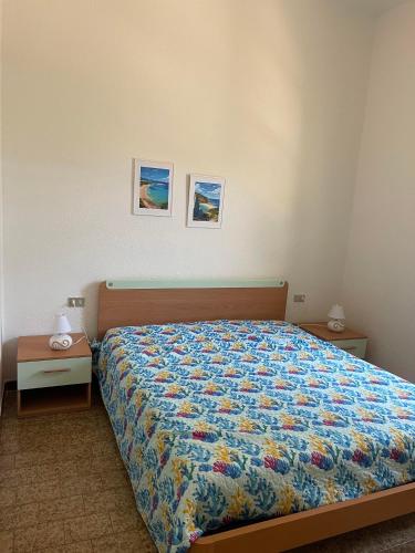 a bedroom with a bed and two pictures on the wall at Villino Sicaru' in Simius