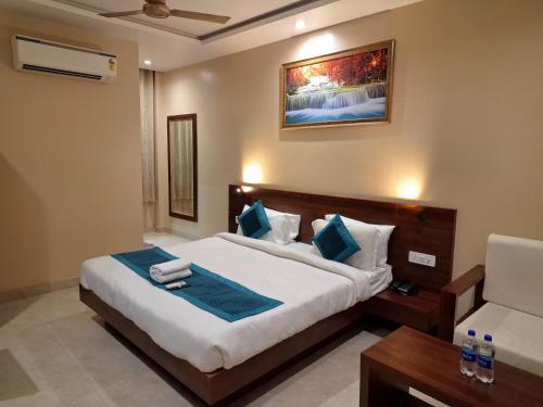 a bedroom with a large bed and a chair at Sangam Hotel in Kiul