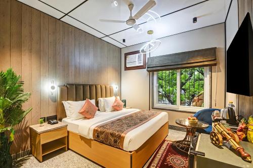 a bedroom with a bed and a tv in a room at J Residency with Free Pickup from Nizamudin Railway Station 12 PM TO 6 PM in New Delhi