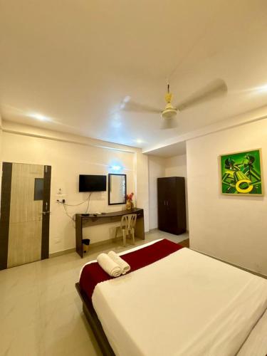a bedroom with a bed and a desk with a television at Silver Key Suites in Nagpur