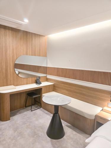 a small room with a bed and a table at Mare Suite Hotel in Incheon
