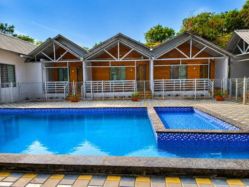 a swimming pool in front of a house at Royal Shouryas Resort in Kolhapur