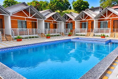 a swimming pool in front of a house at Royal Shouryas Resort in Kolhapur