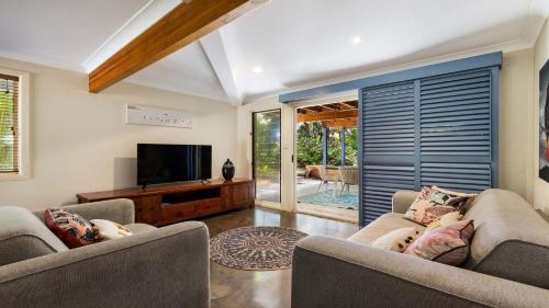 a living room with two couches and a flat screen tv at Salty Seaside in New Brighton