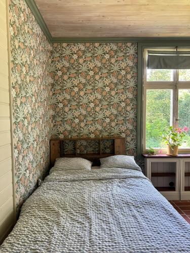 ein Schlafzimmer mit einem Bett in einem Zimmer mit Tapete in der Unterkunft Vitsand 