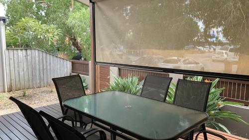a green table and chairs on a deck with a window at Hook Wine & Sinker in Brunswick Heads