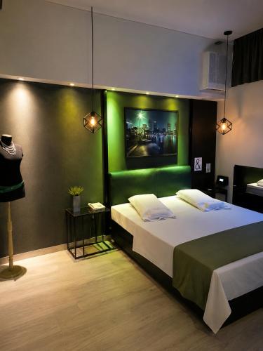 a bedroom with a large bed with a green wall at Hotel Castelar suit in Castelar