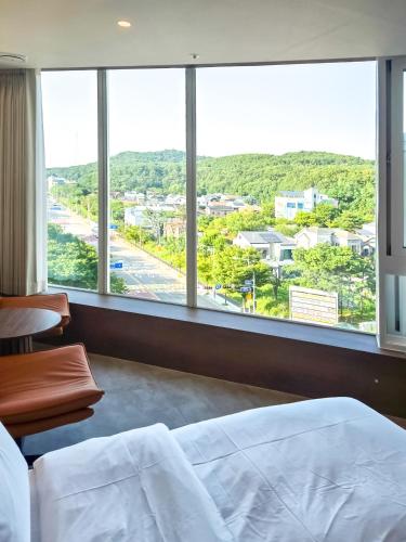a bedroom with a bed and a large window at Mare Suite Hotel in Incheon