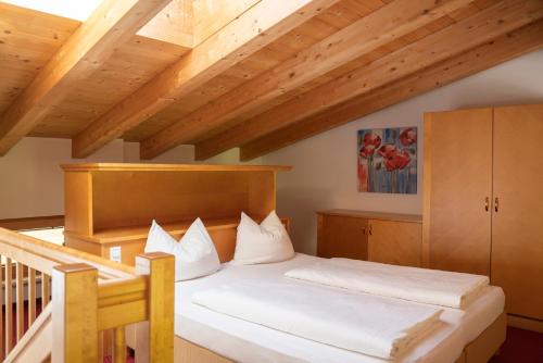a bedroom with a bed and a wooden ceiling at Aparthotel Schindlhaus/Alpin in Söll