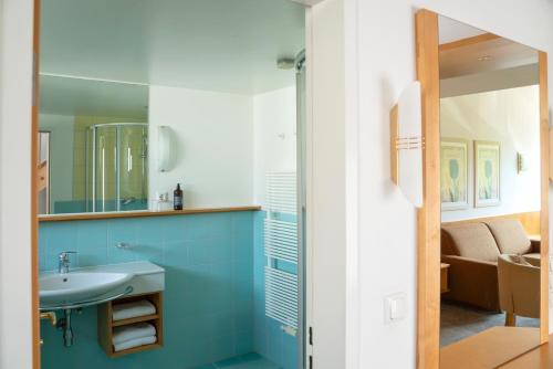 a bathroom with a sink and a mirror at Aparthotel Schindlhaus/Alpin in Söll