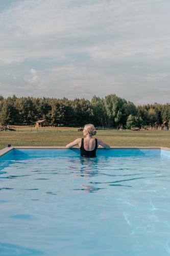 a woman is standing in a swimming pool at Liva Park Nature Resort in Liwa