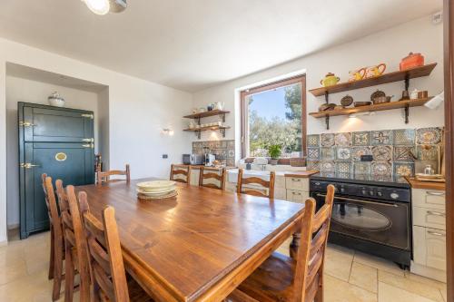 a kitchen with a wooden table and a dining room at Trulli Oasis in Noci