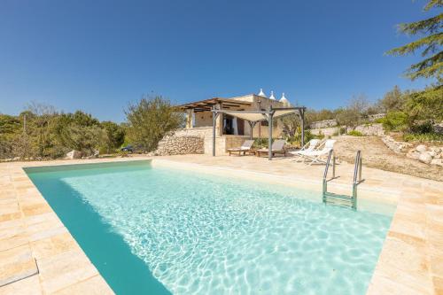 a swimming pool in front of a house at Trulli Oasis in Noci