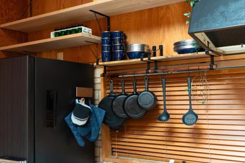 a kitchen with pots and pans and utensils on a wall at MOSAIC hinohara in Motojuku