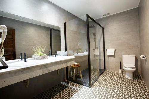a bathroom with two sinks and a shower and a toilet at Hotel Convento San Roque in Balmaseda